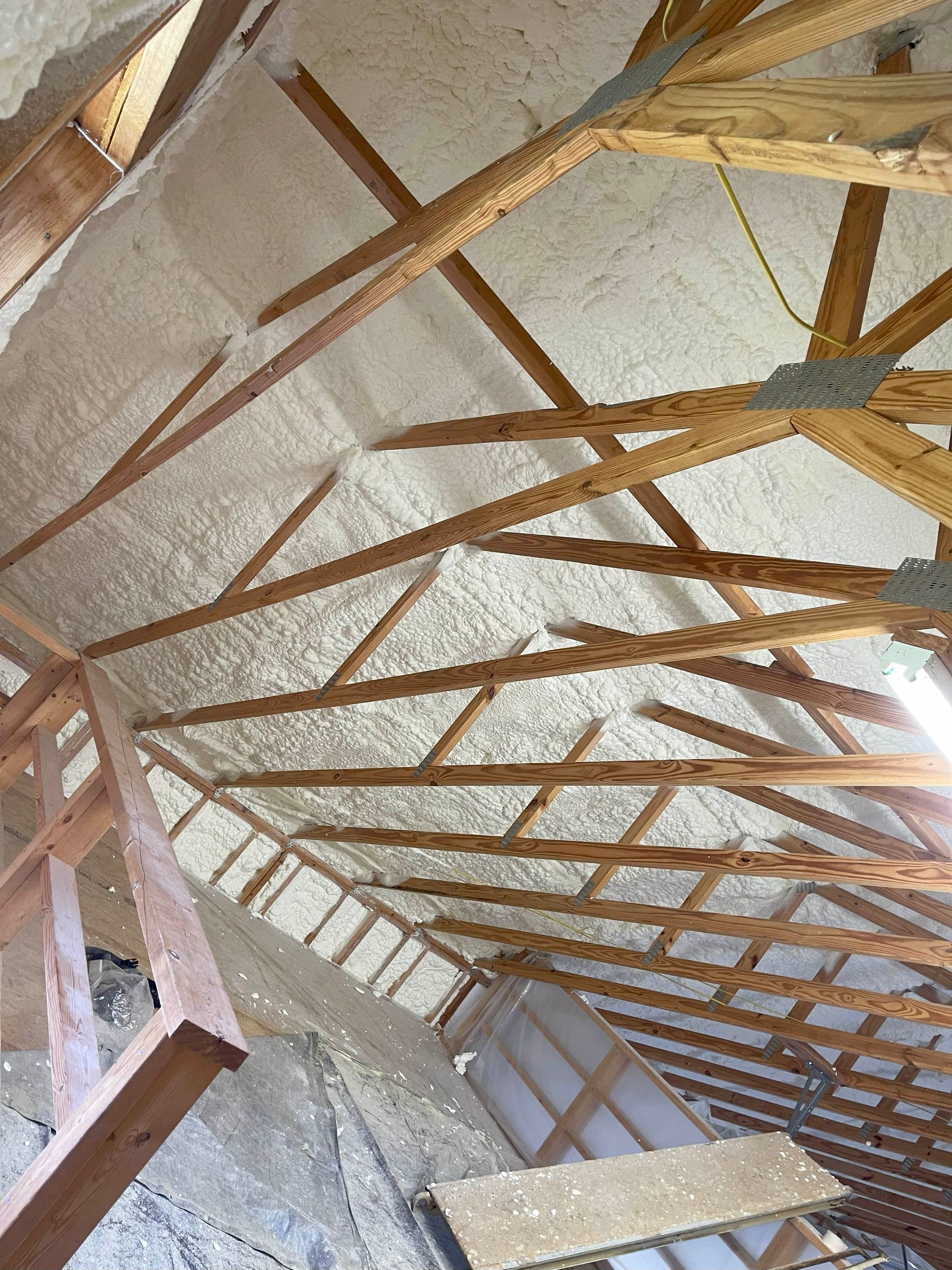 The ceiling of a building is covered in foam and wooden beams.