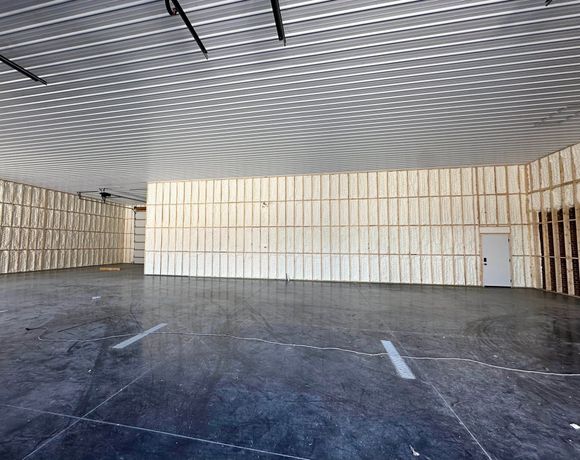 A large empty room with wooden walls and a ceiling.