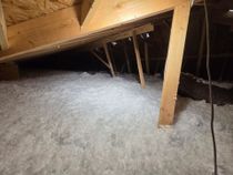 There is a lot of insulation in the attic of a house.