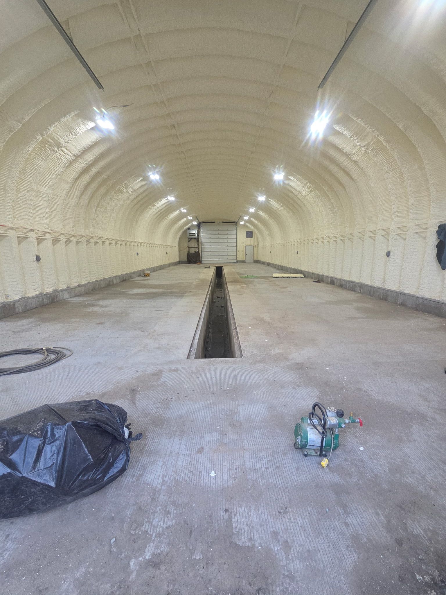 A large empty building with a drain in the middle of it.