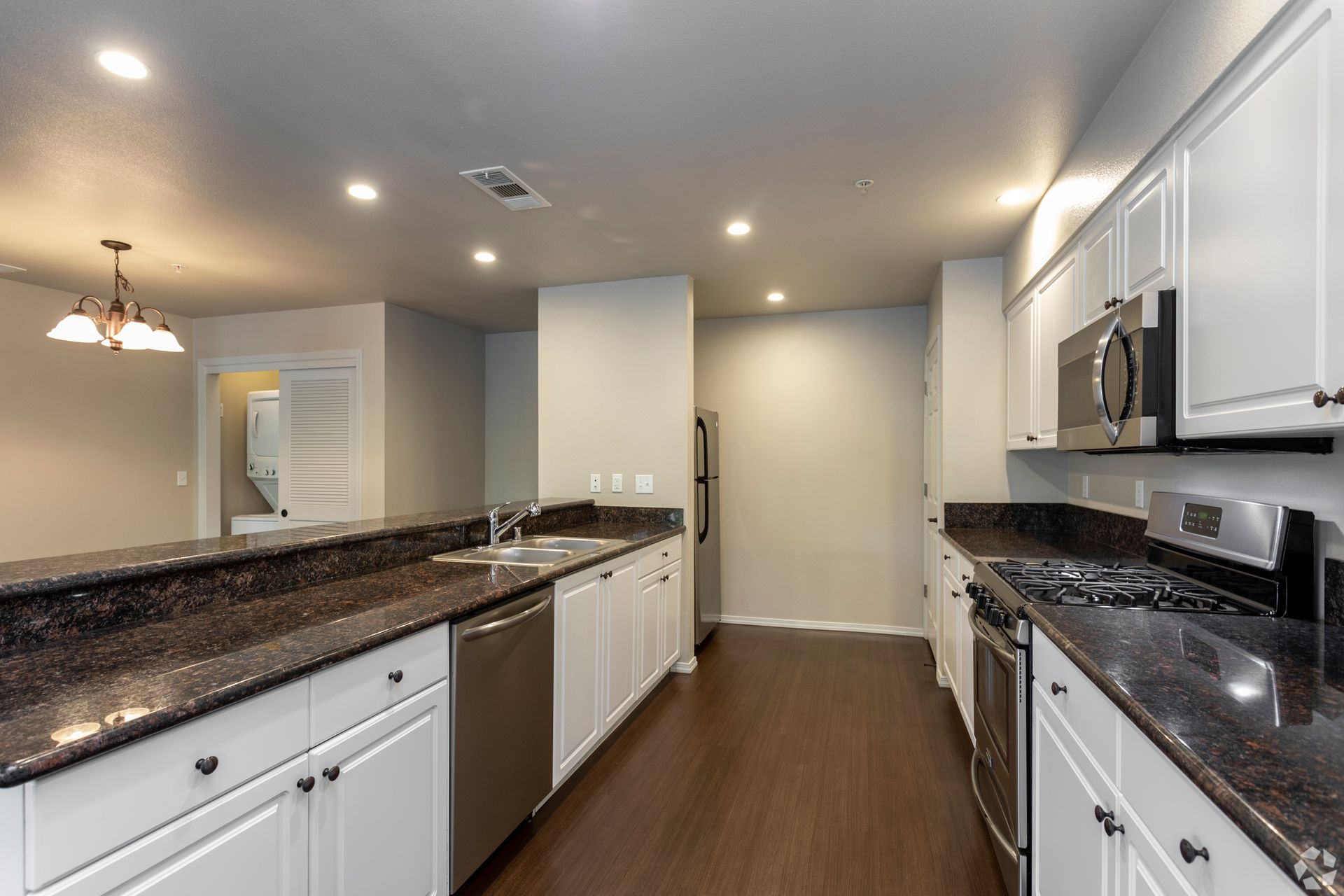 Kitchen with white cabinets, dark countertops, and stainless steel appliances.