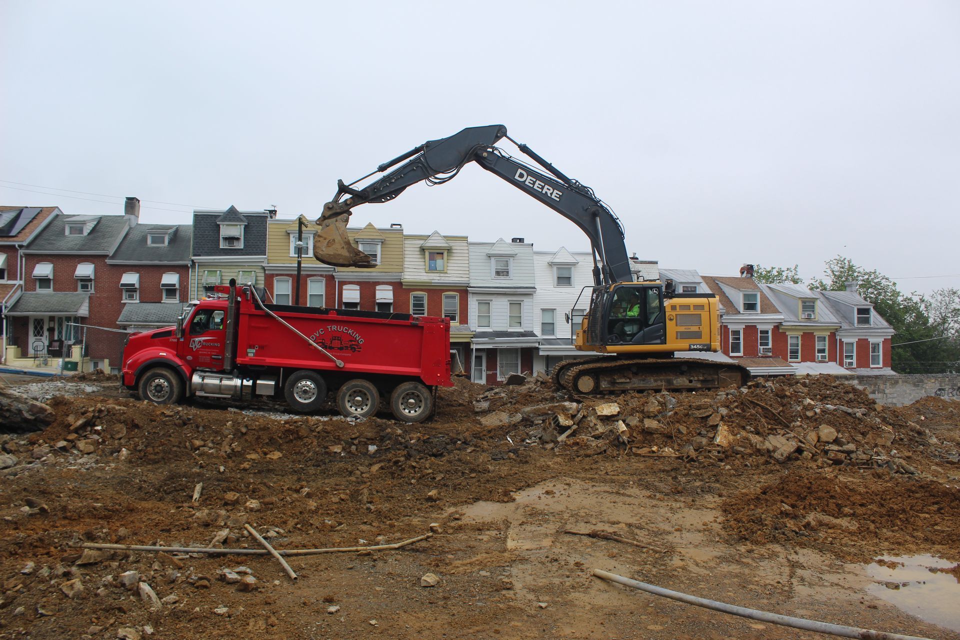 DVC dump truck receives a load of dirt and concrete from pool demolition project.