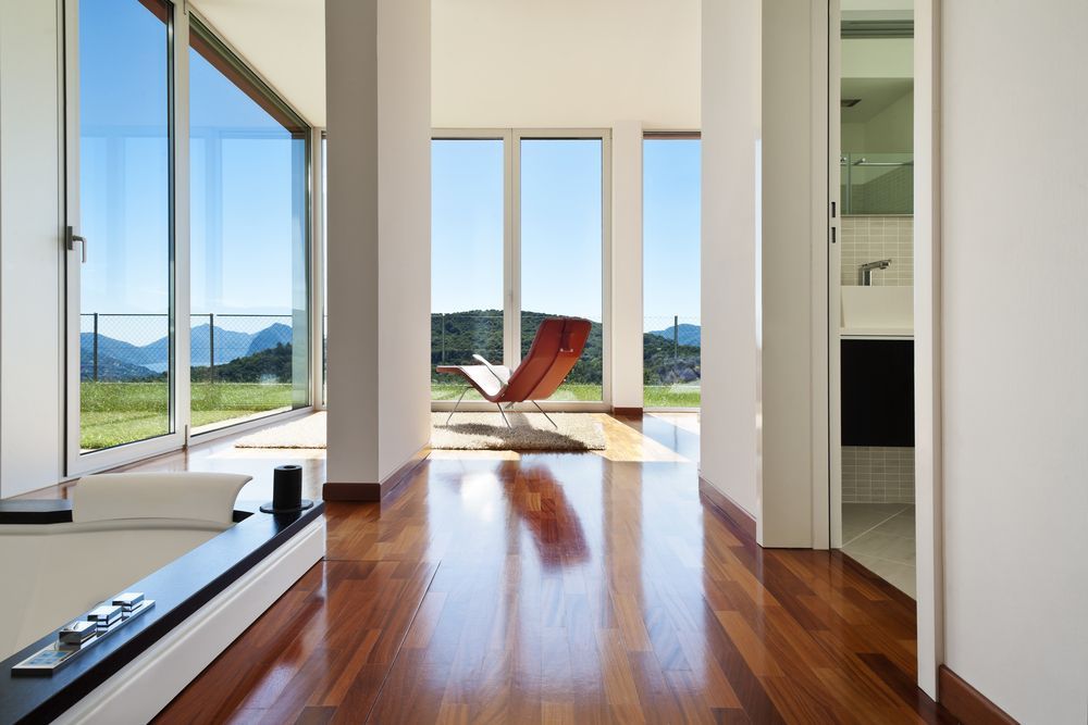 A Living Room with Hardwood Floors and Lots of Windows — Geoff Thompson's Independent Flooring Centre In Port Macquarie, NSW