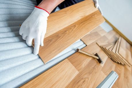 A Person Is Installing a Wooden Floor in A Room — Geoff Thompson's Independent Flooring Centre In Port Macquarie, NSW