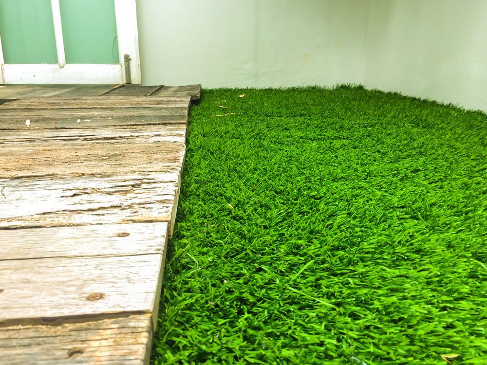 Wooden Walkway Next to Green Artificial Turf — Geoff Thompson's Independent Flooring Centre in Taree, NSW