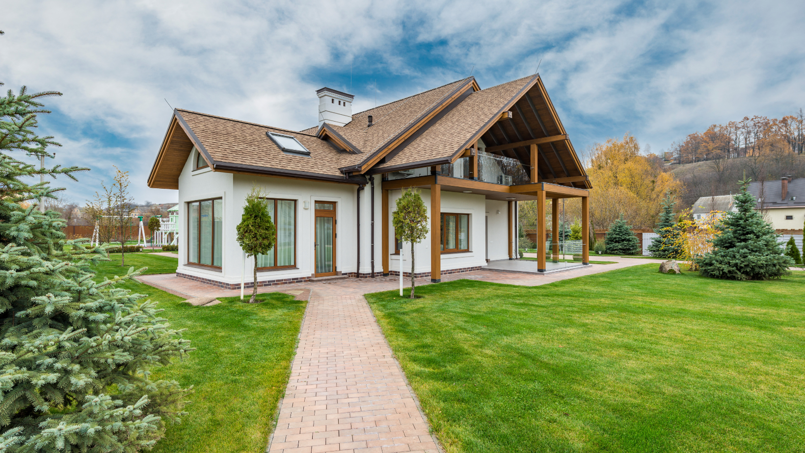 A large white house with a wooden roof and a walkway leading to it.