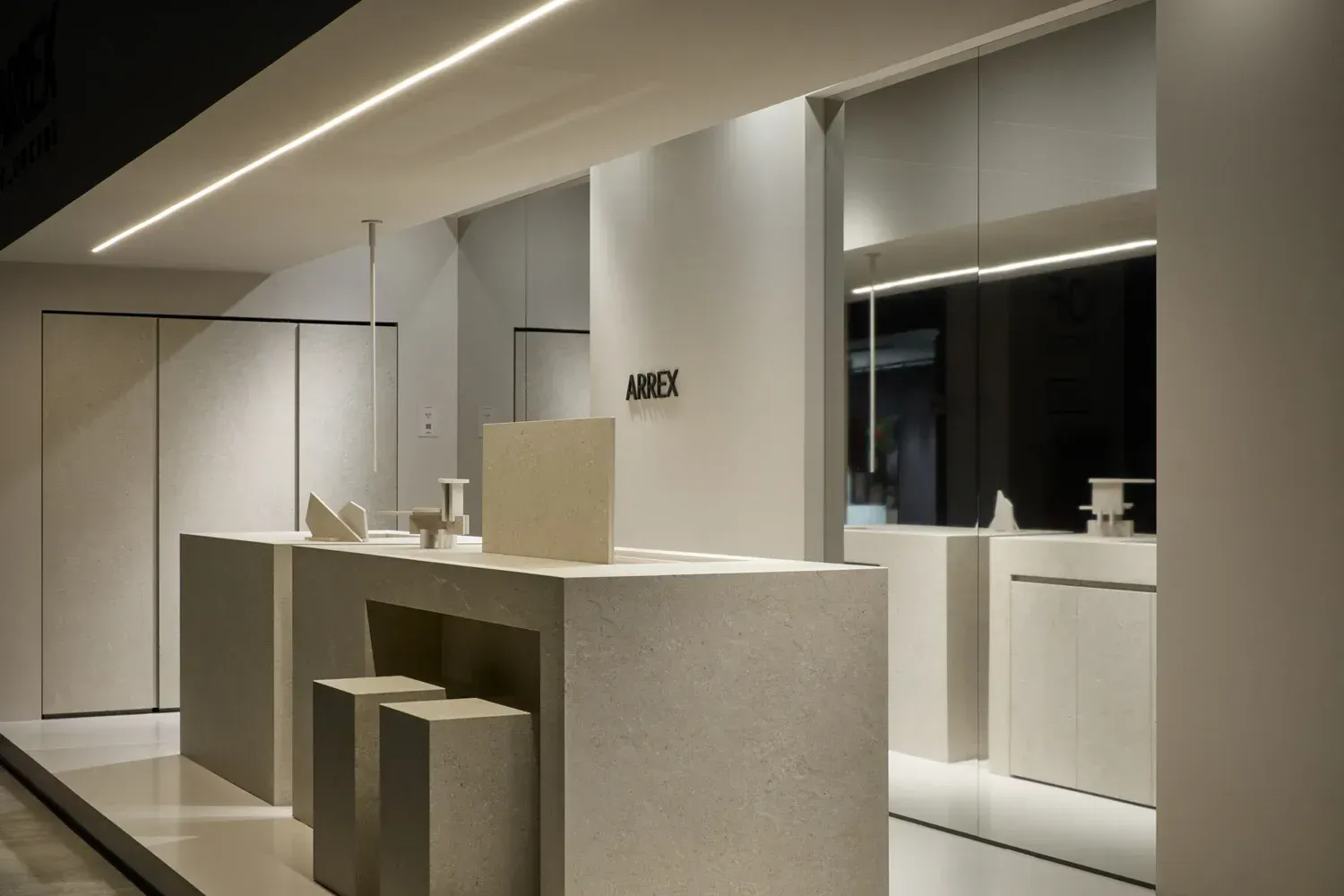 Un negozio moderno e minimalista con banconi bianchi, illuminazione da incasso e una tavolozza di colori neutri.