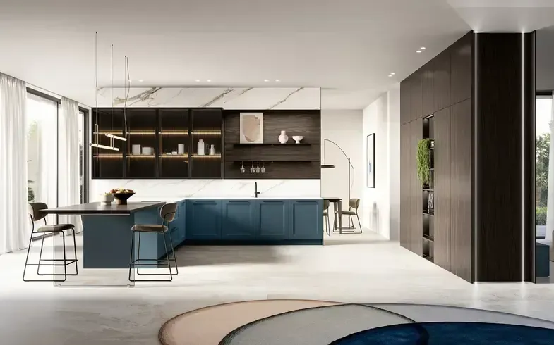 Cucina moderna con mobili blu, paraschizzi in marmo e contenitori in legno scuro. In primo piano, un'isola scura con sedute.