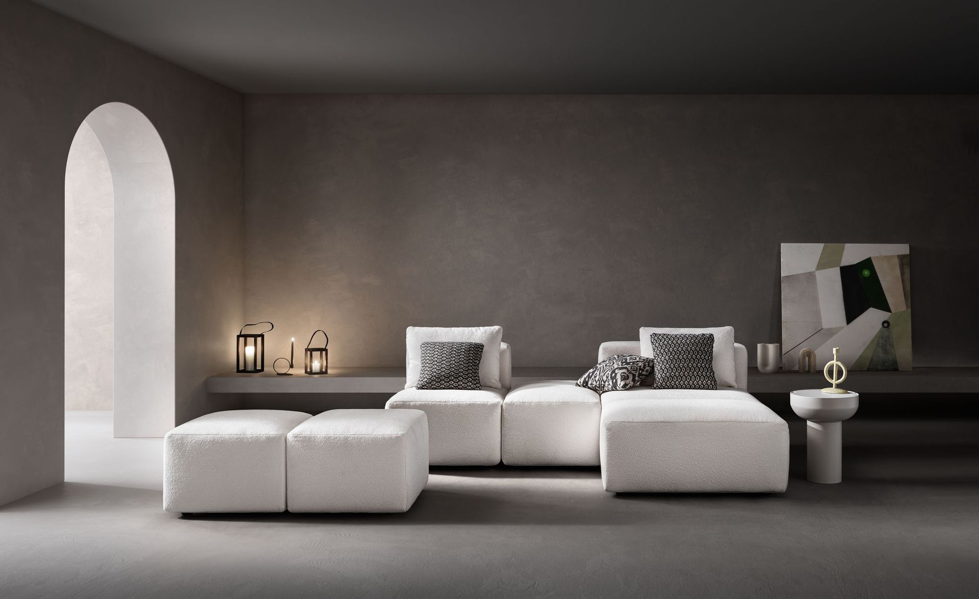 Un soggiorno moderno con un divano componibile bianco, una porta ad arco e un'opera d'arte astratta su una parete grigio scuro.