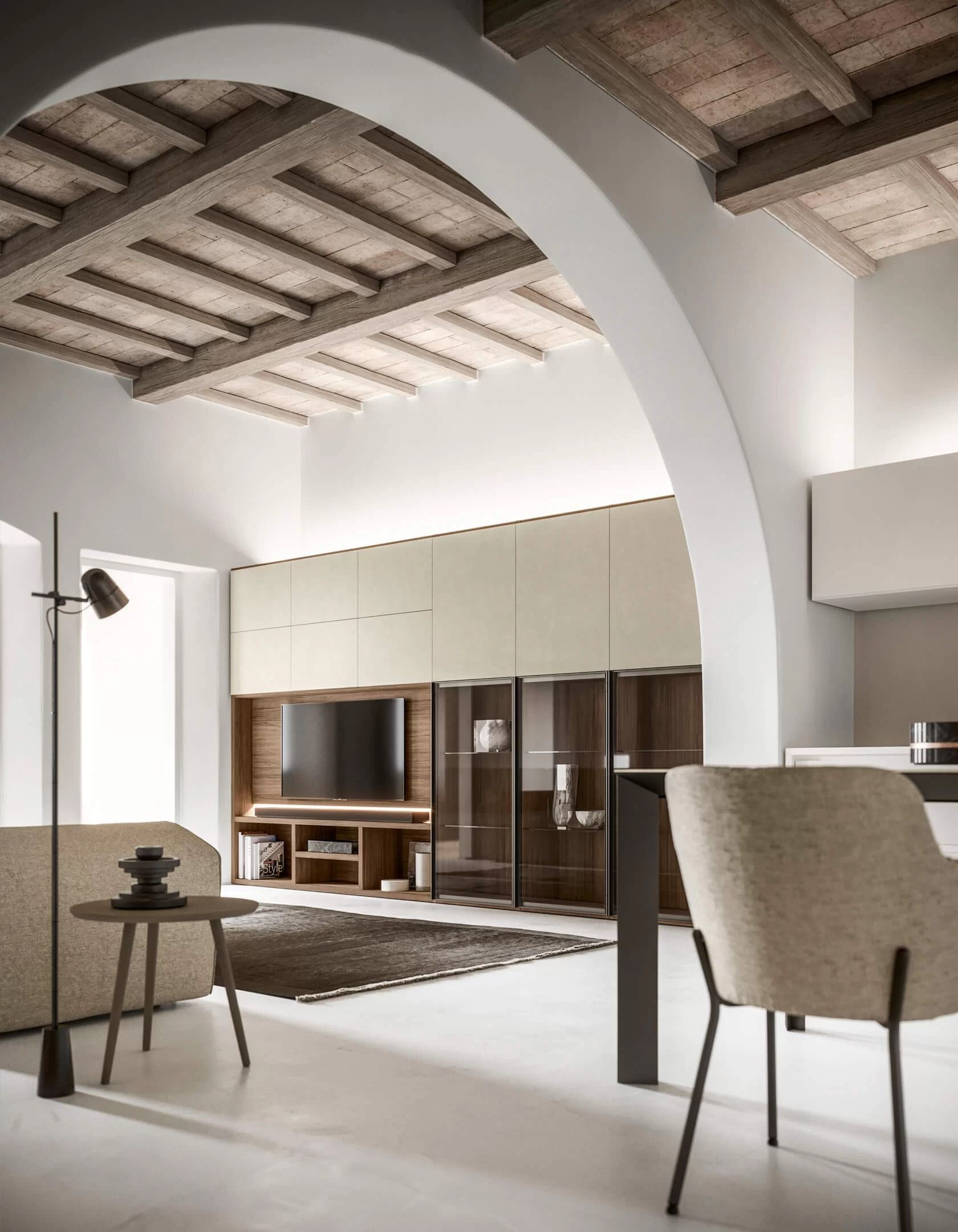 Soggiorno moderno con soffitti alti, arco, pareti chiare, travi in legno e spazio di archiviazione incorporato.