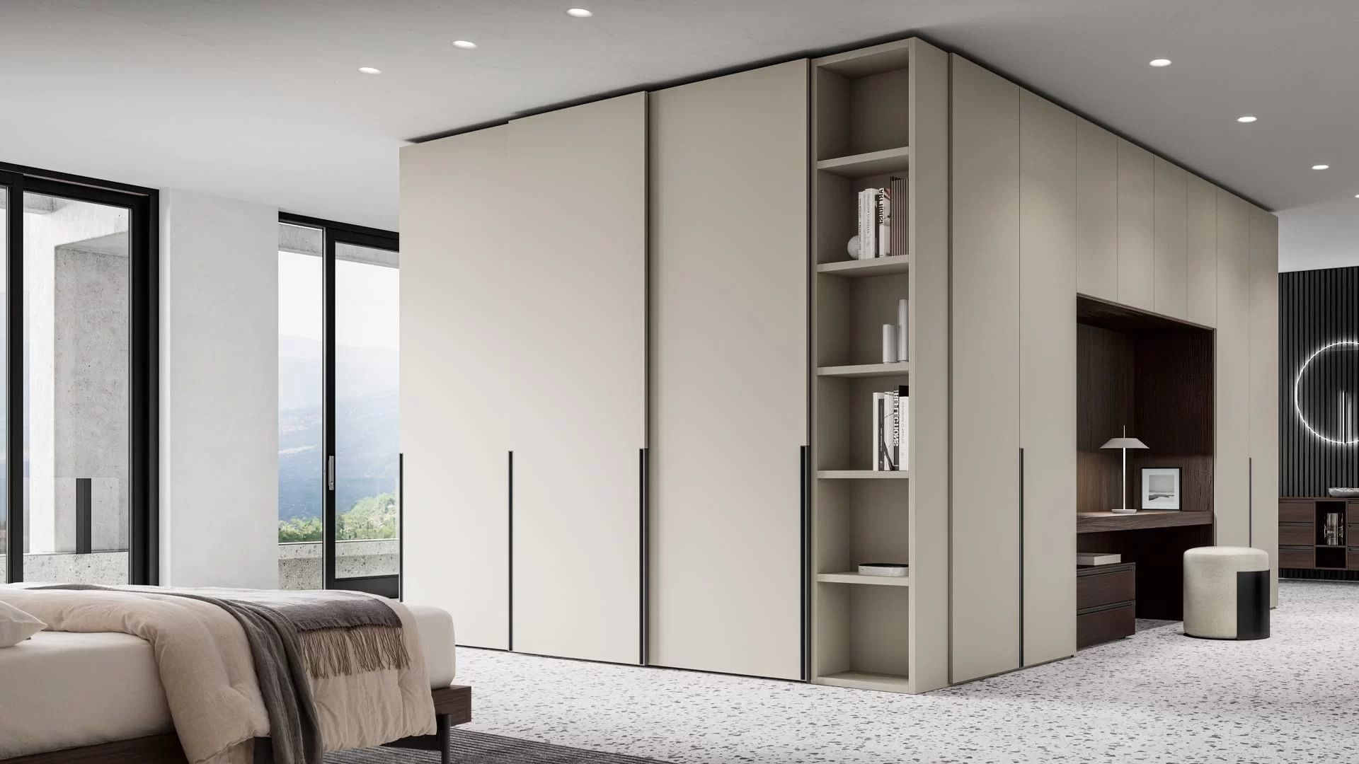 Camera da letto moderna con un ampio armadio a muro dai toni neutri. L'armadio è dotato di ante scorrevoli, ripiani a giorno con libri e una scrivania integrata.