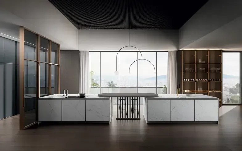 Cucina moderna con due isole con piano in marmo, ampie finestre con vista e soffitto scuro.