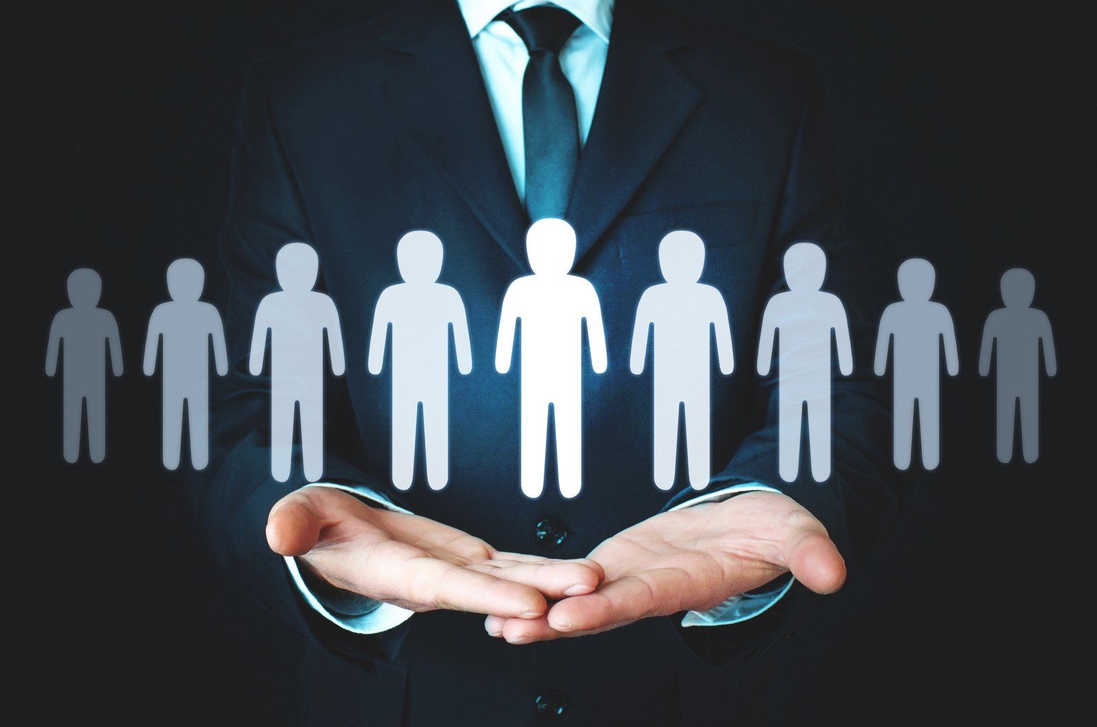 A man in a suit and tie is holding a group of people in his hands.