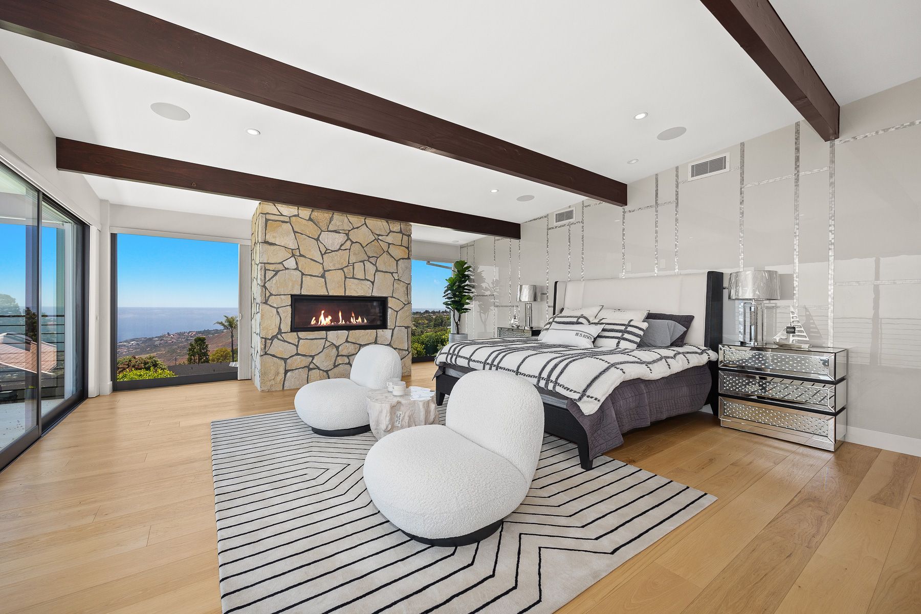 Photo showing a bedroom with its own fireplace and plenty of natural lighting, as well as lots of open space