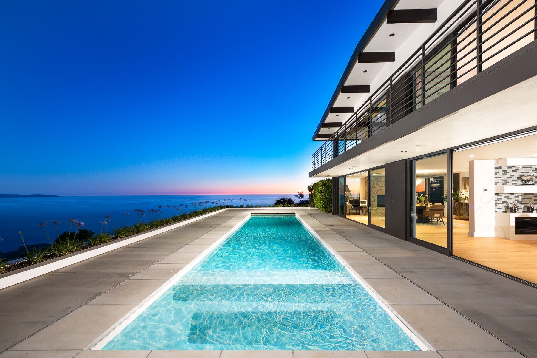 Photo showing a long pool outside of an upscale home