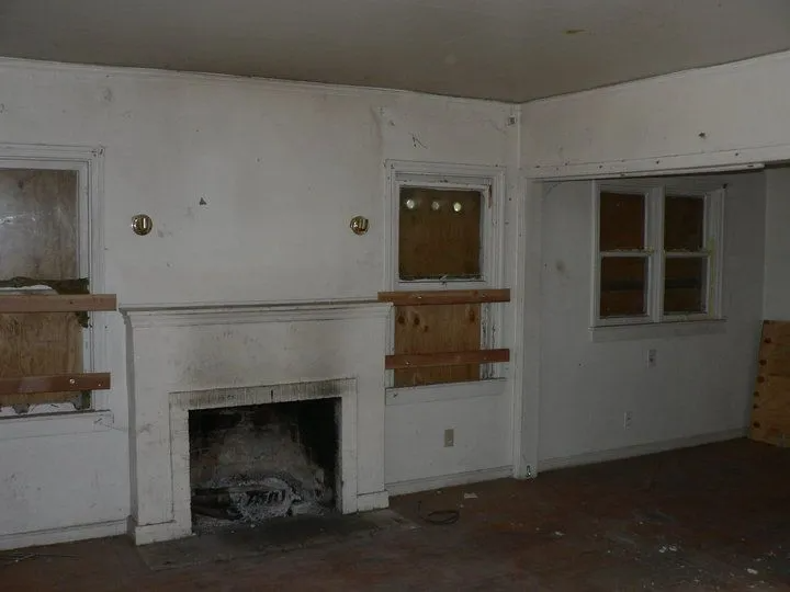 An empty room with a fireplace and a window