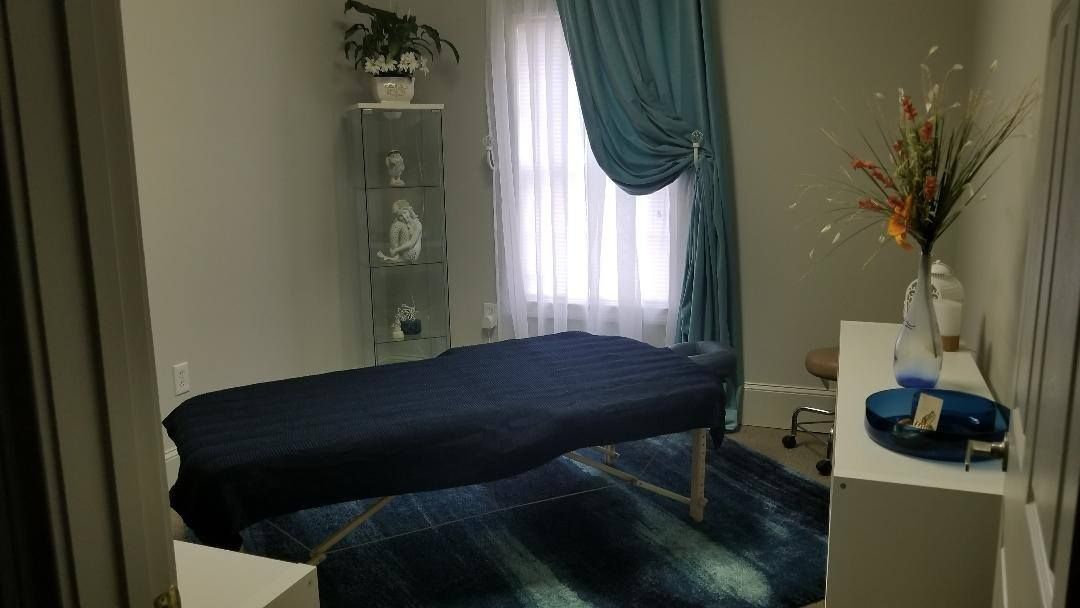 A massage table is sitting in a room next to a window.