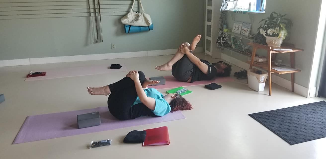 Two people are laying on yoga mats in a room.