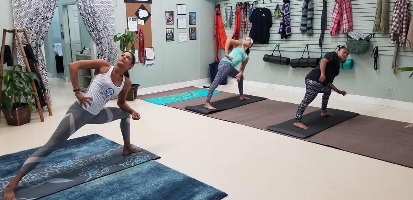 A group of people are doing yoga in a gym.