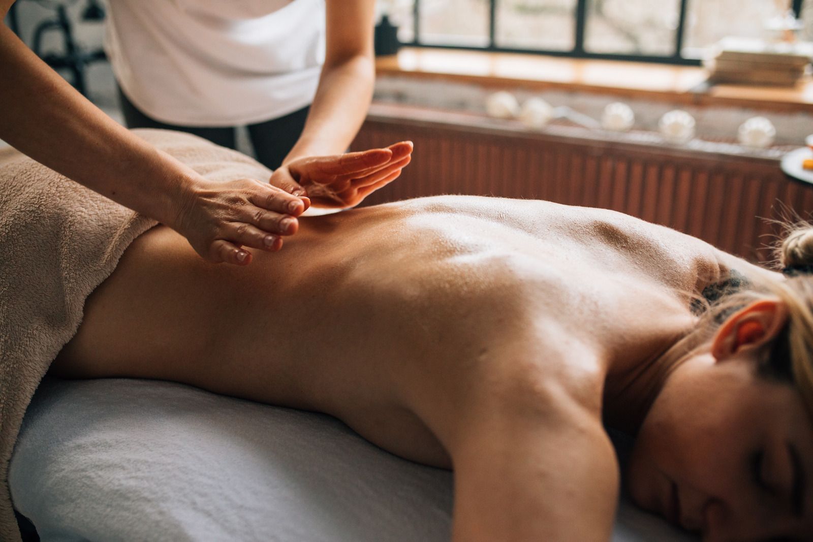A woman is laying on a massage table getting a massage.
