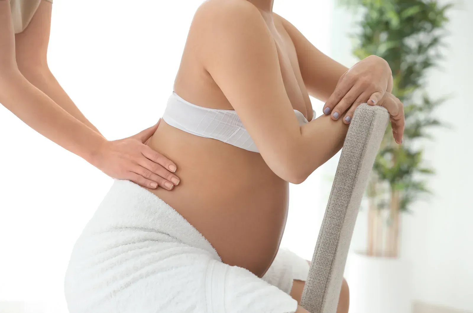 A pregnant woman is getting a massage at a spa.