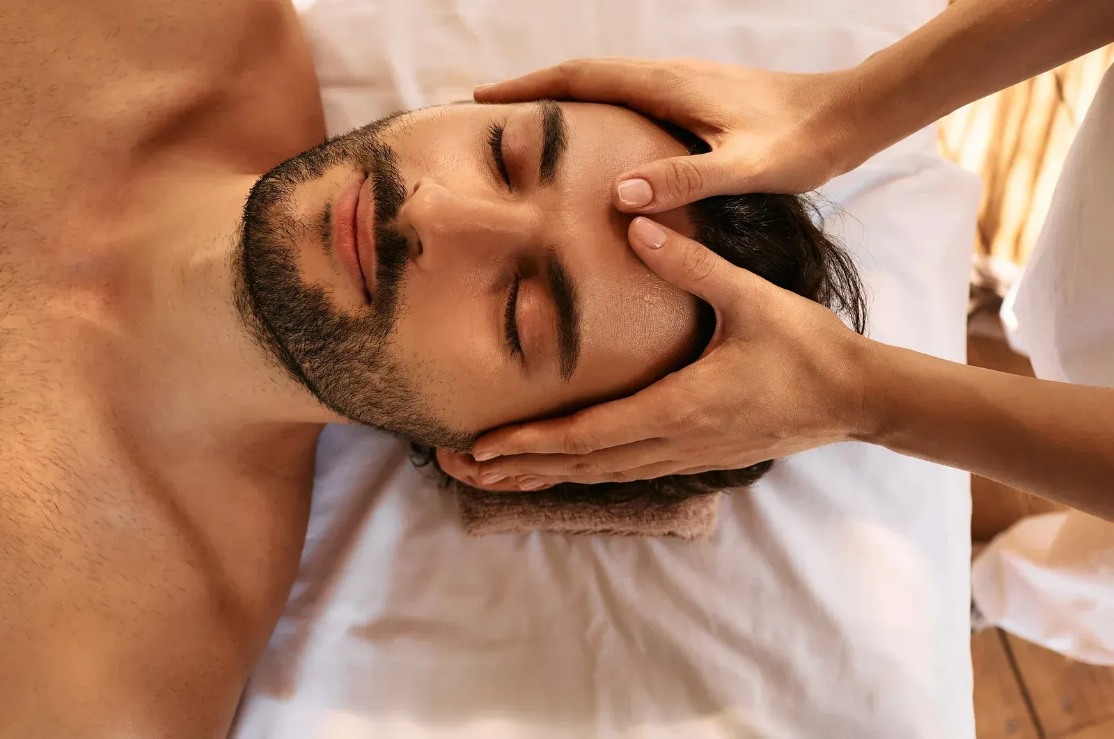 A man is getting a head massage at a spa.