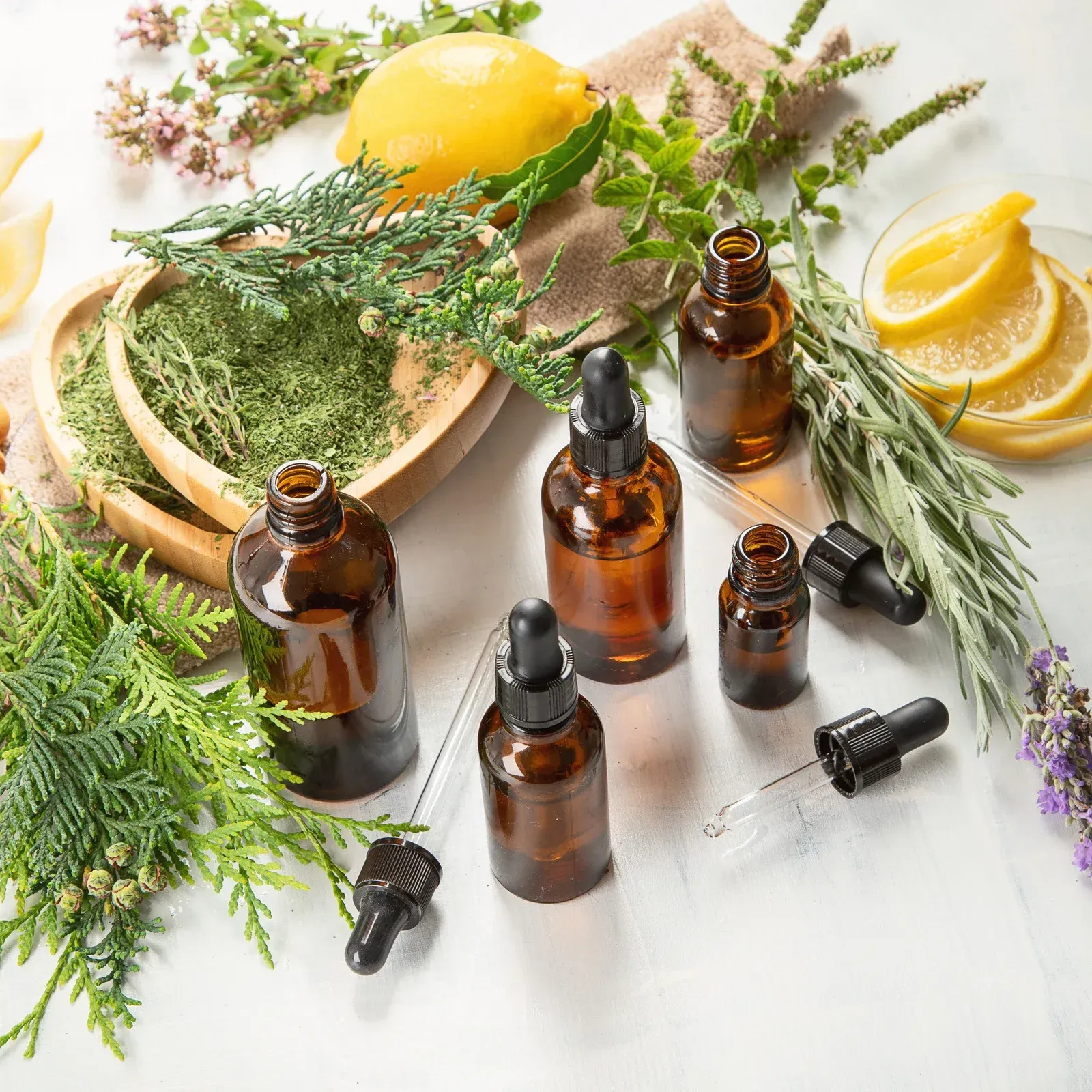 A table topped with bottles of essential oils and herbs.