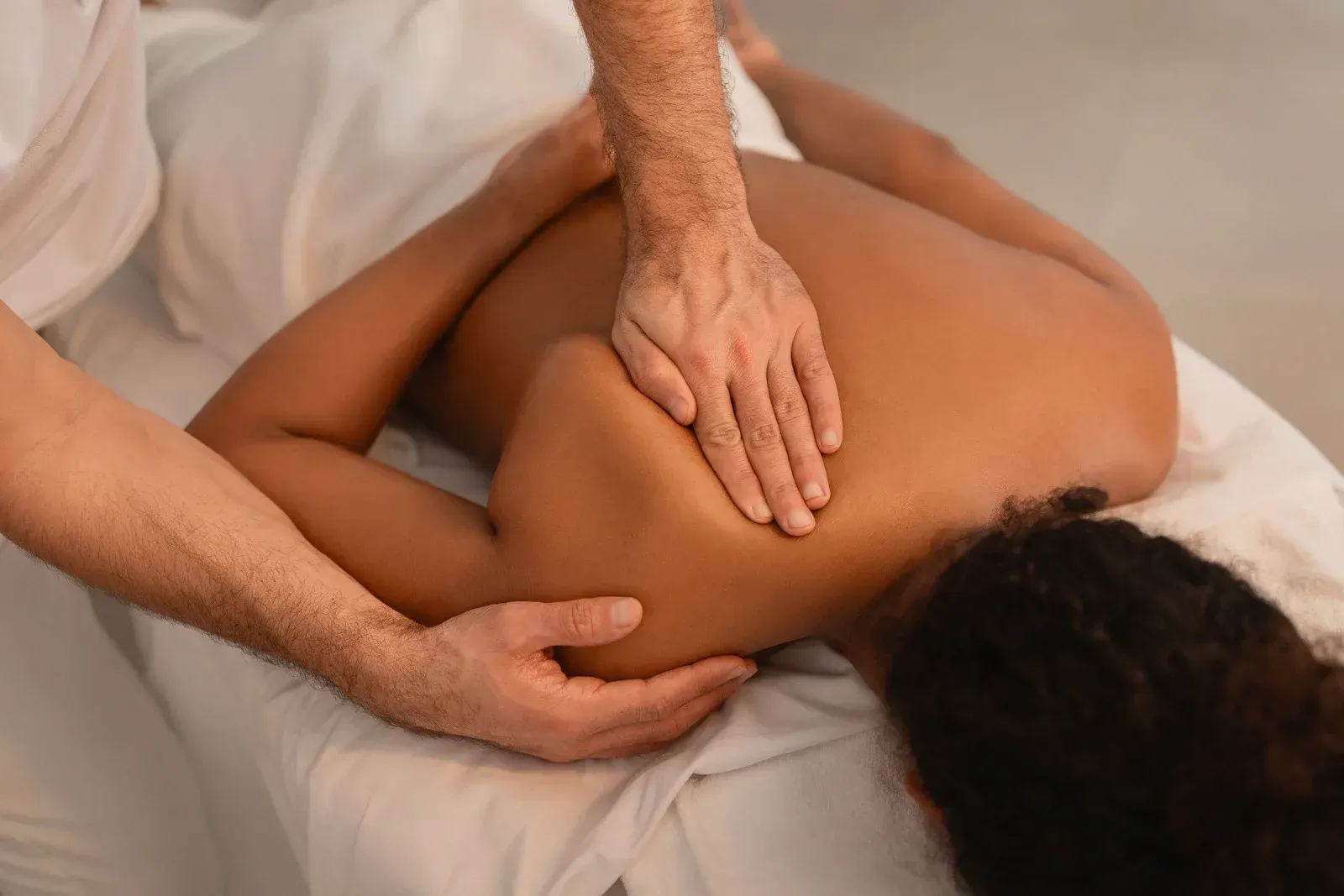 A man is giving a woman a massage on her back.