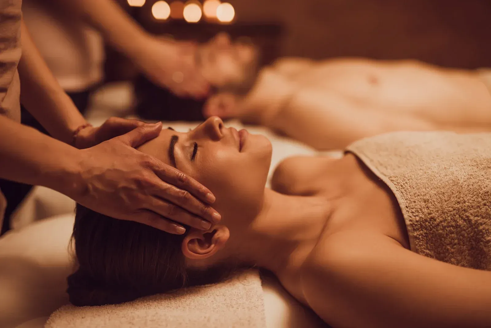 A man and a woman are getting a massage at a spa.