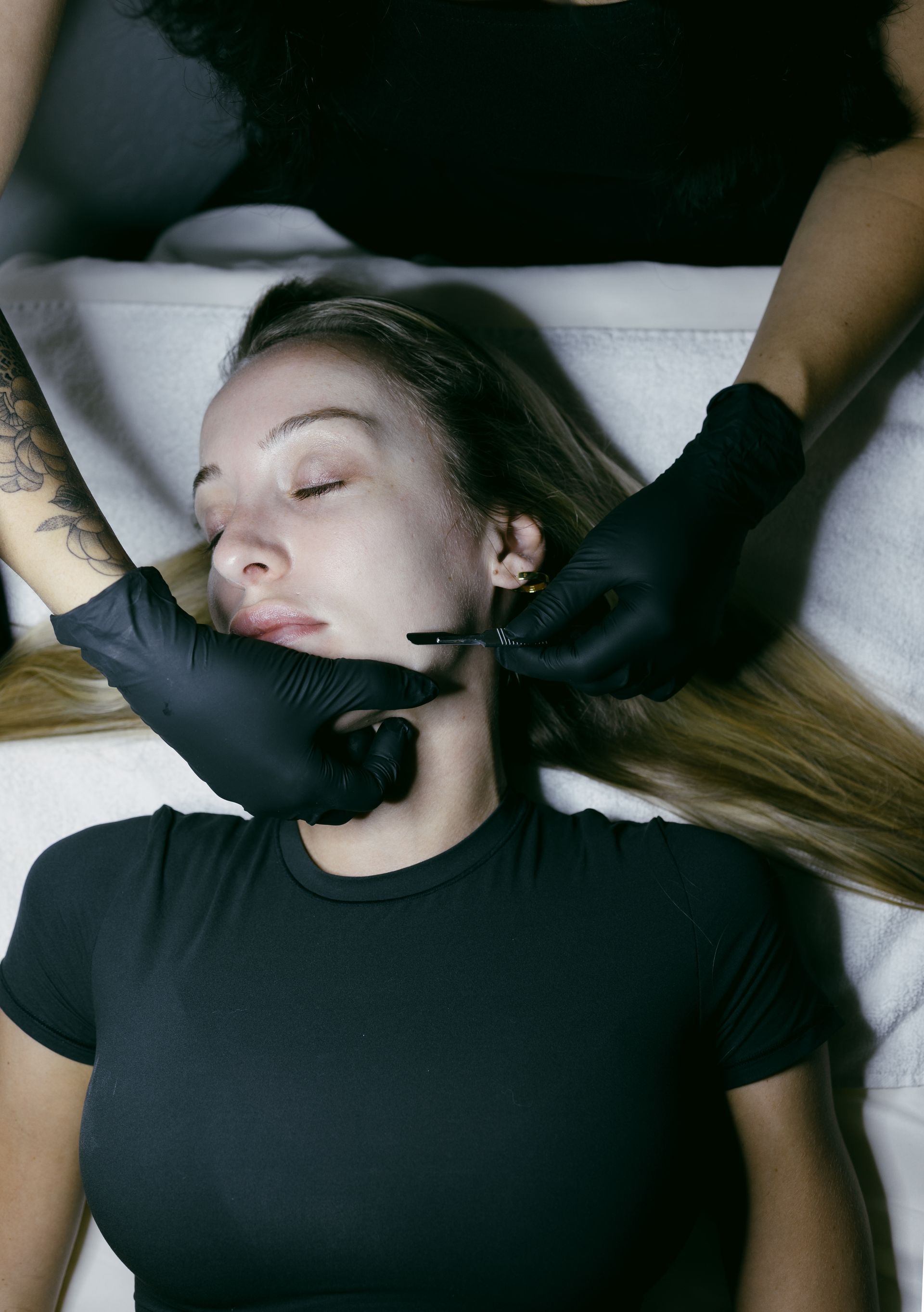 A woman receiving a dermaplaning facial at a skincare studio