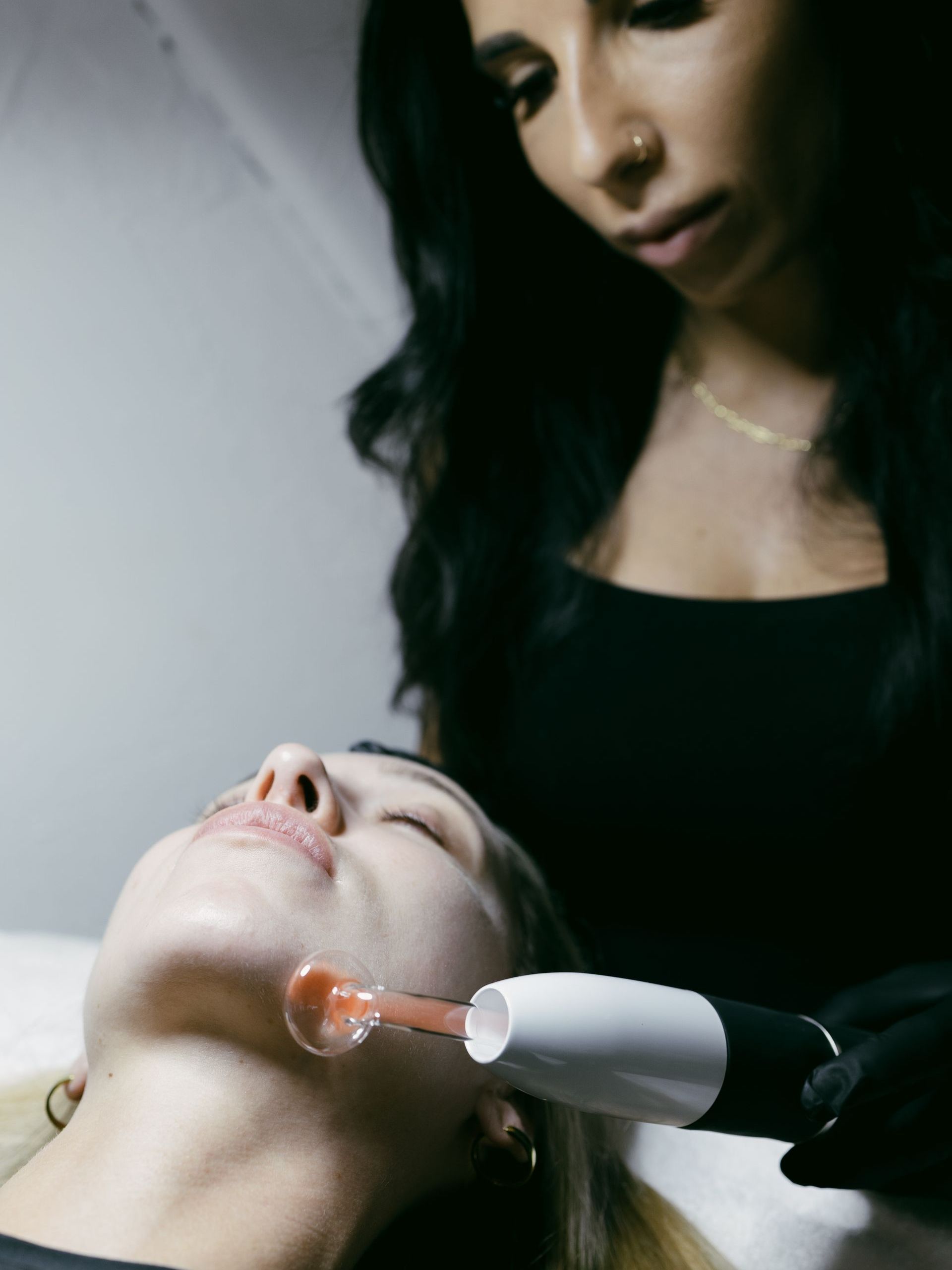 A woman is getting a facial treatment at a skincare studio.