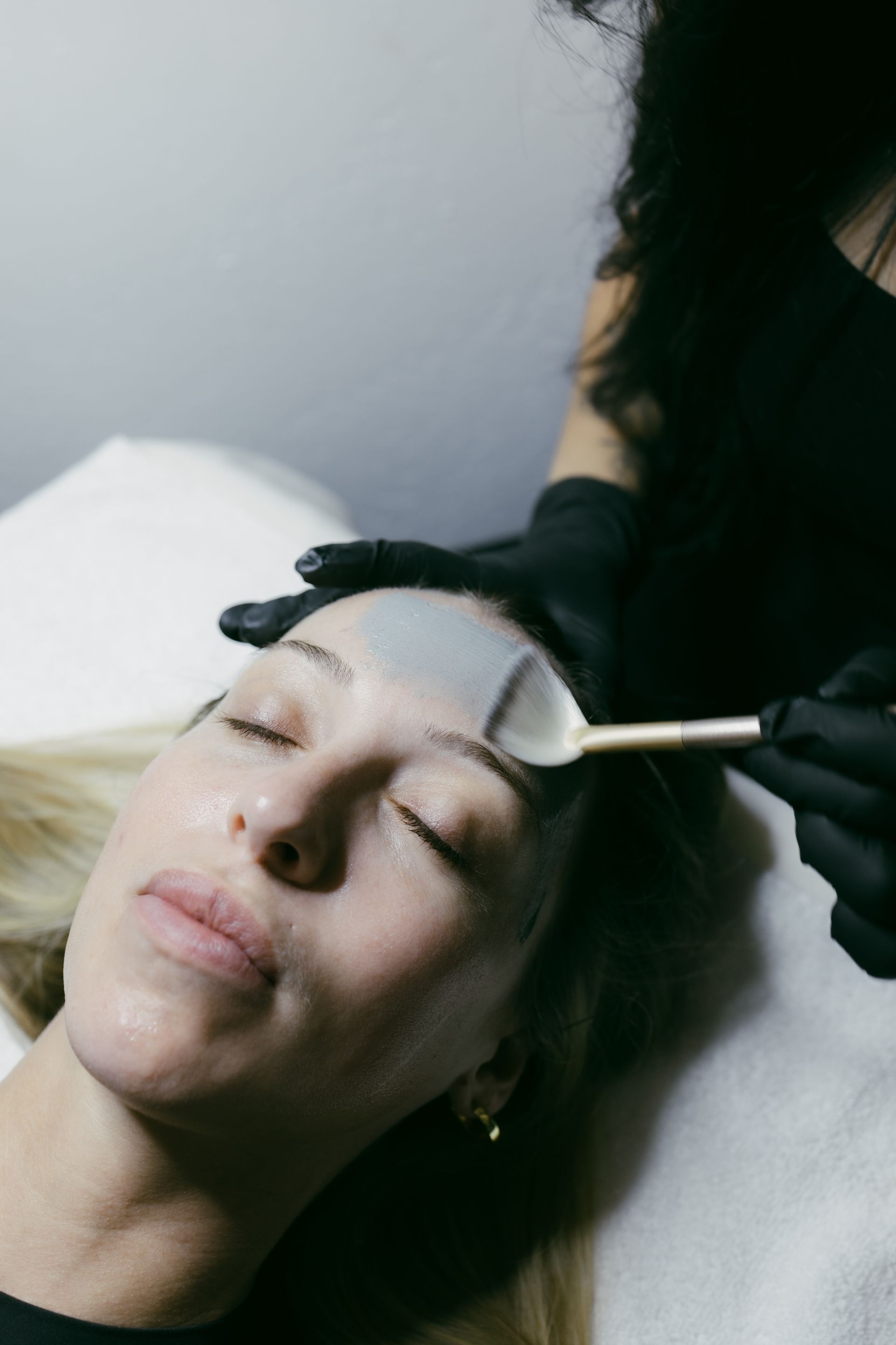 A woman is getting a facial treatment at a skincare studio