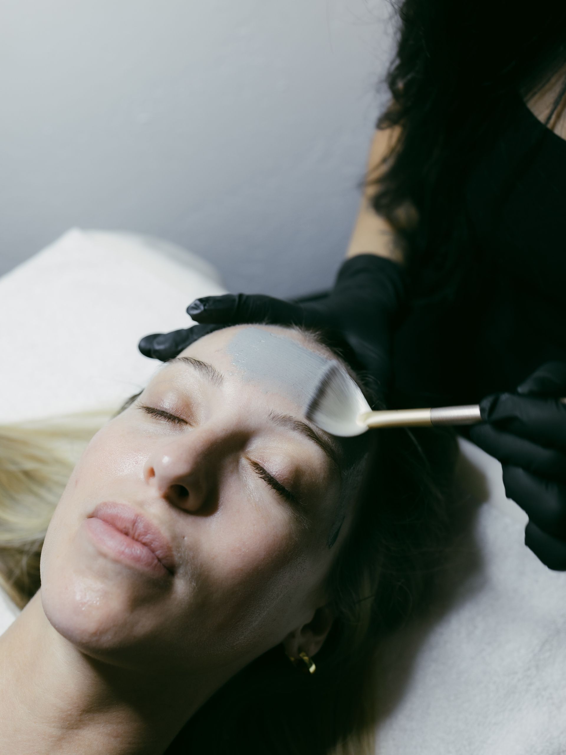 A woman is getting a facial treatment at a beauty salon.