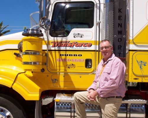 Man Sits on a Stool in Front of a Kenworth Truck — Transforce in Bathurst, NSW