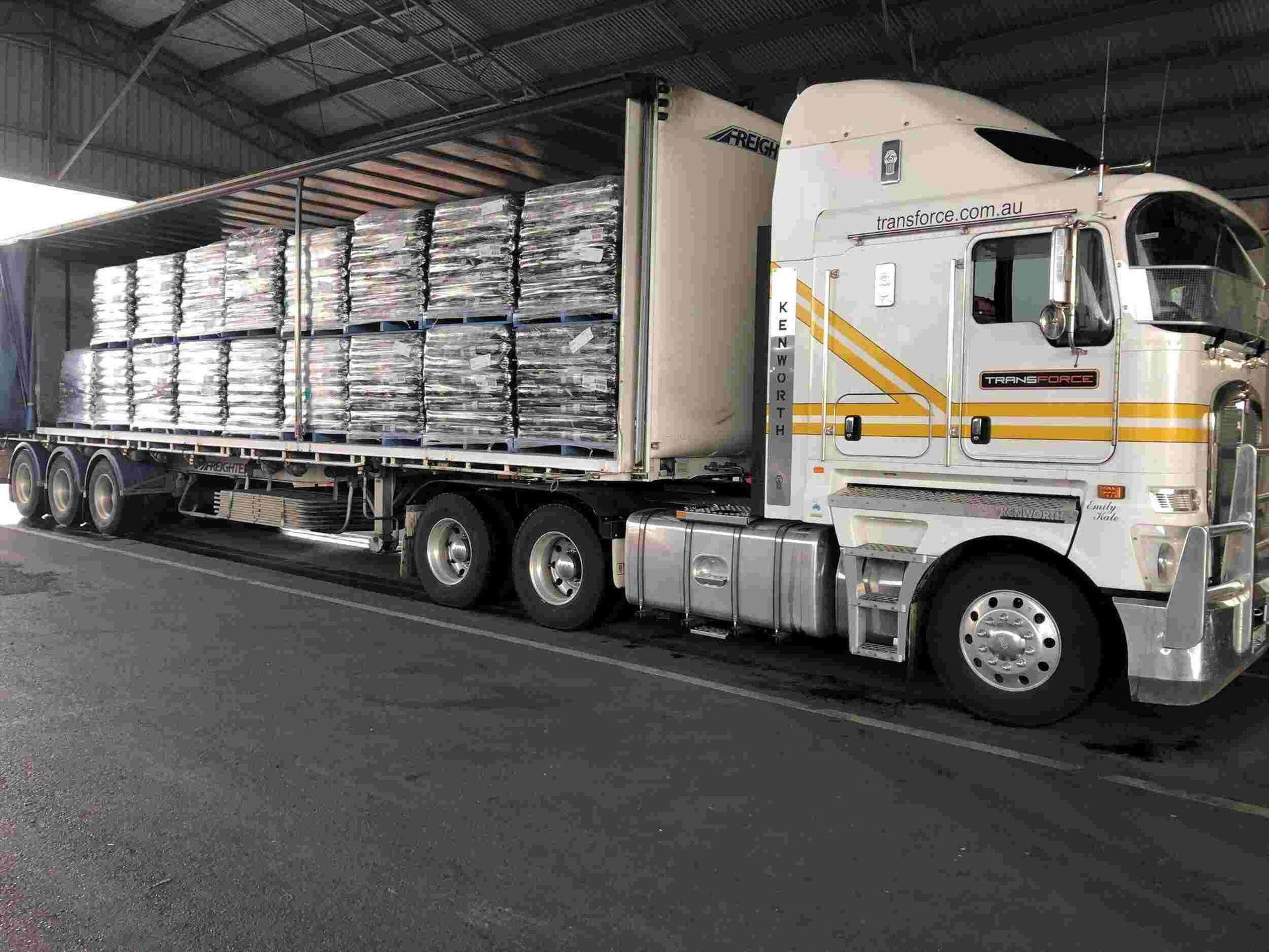 Semi Truck is Parked in a Warehouse Filled With Lots of Bags — Transforce in Dubbo, NSW