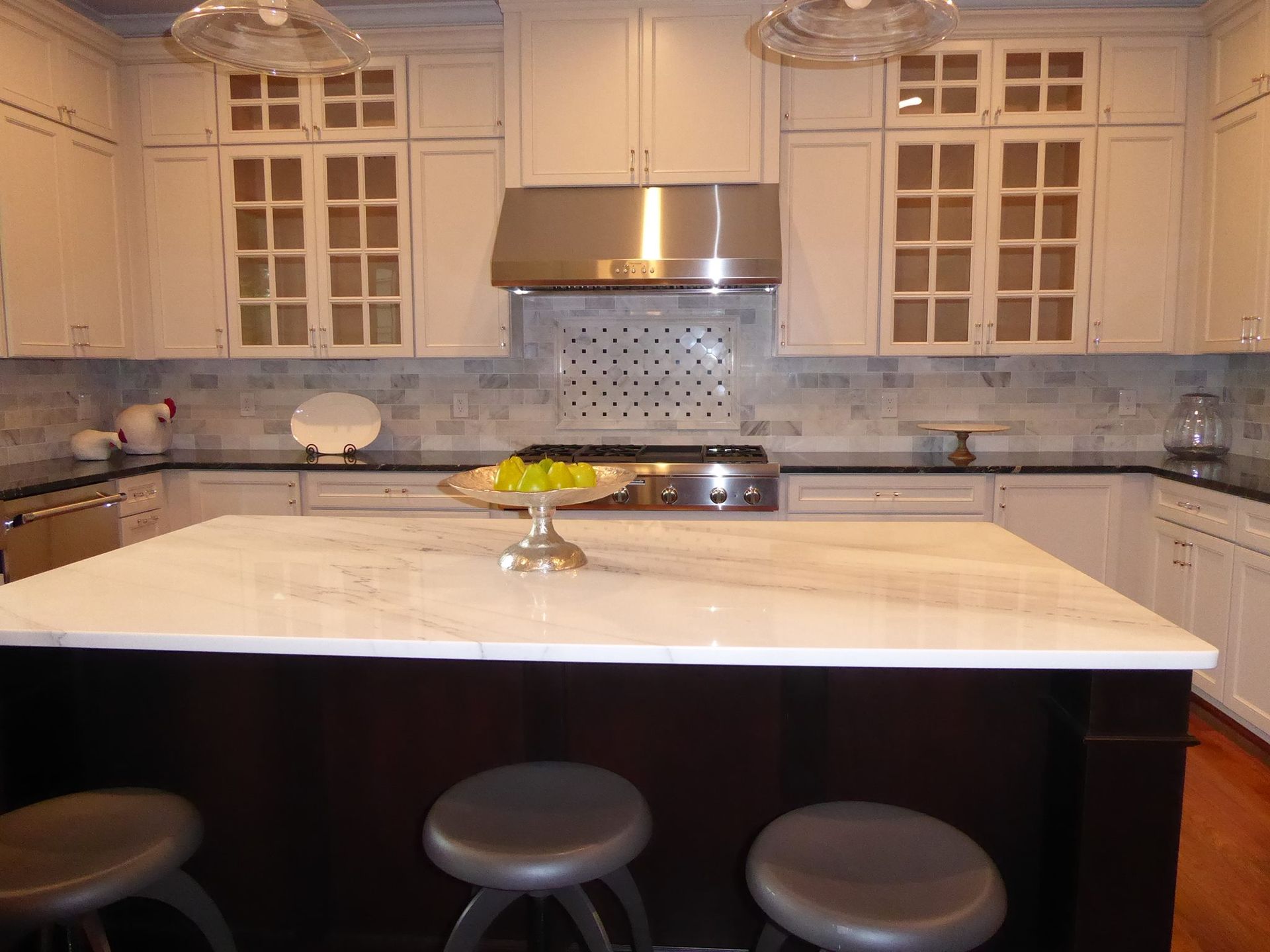 A kitchen with white cabinets and stainless steel appliances
