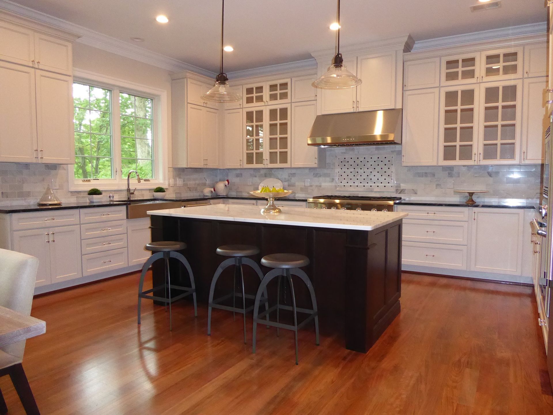 A kitchen with white cabinets and a large island in the middle