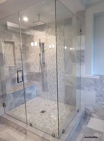 A bathroom with a walk in shower with a glass door.