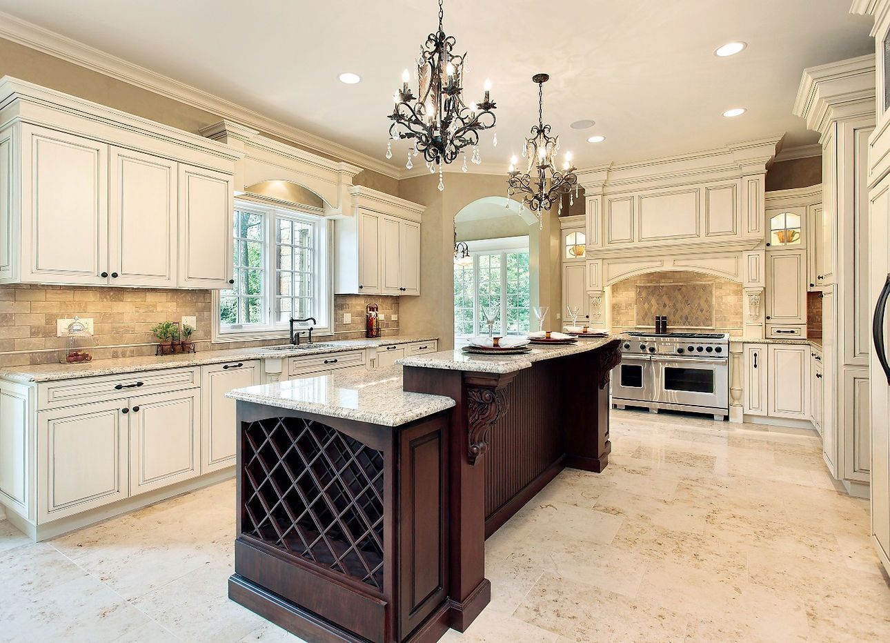 A large kitchen with white cabinets and a large island.