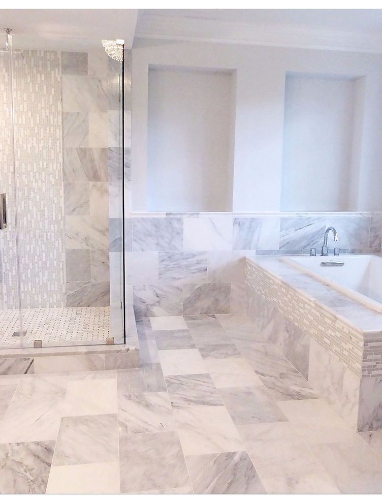 A bathroom with a tub , shower , and walk in shower.