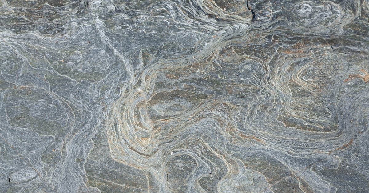 A close up of a white granite counter top with black spots.