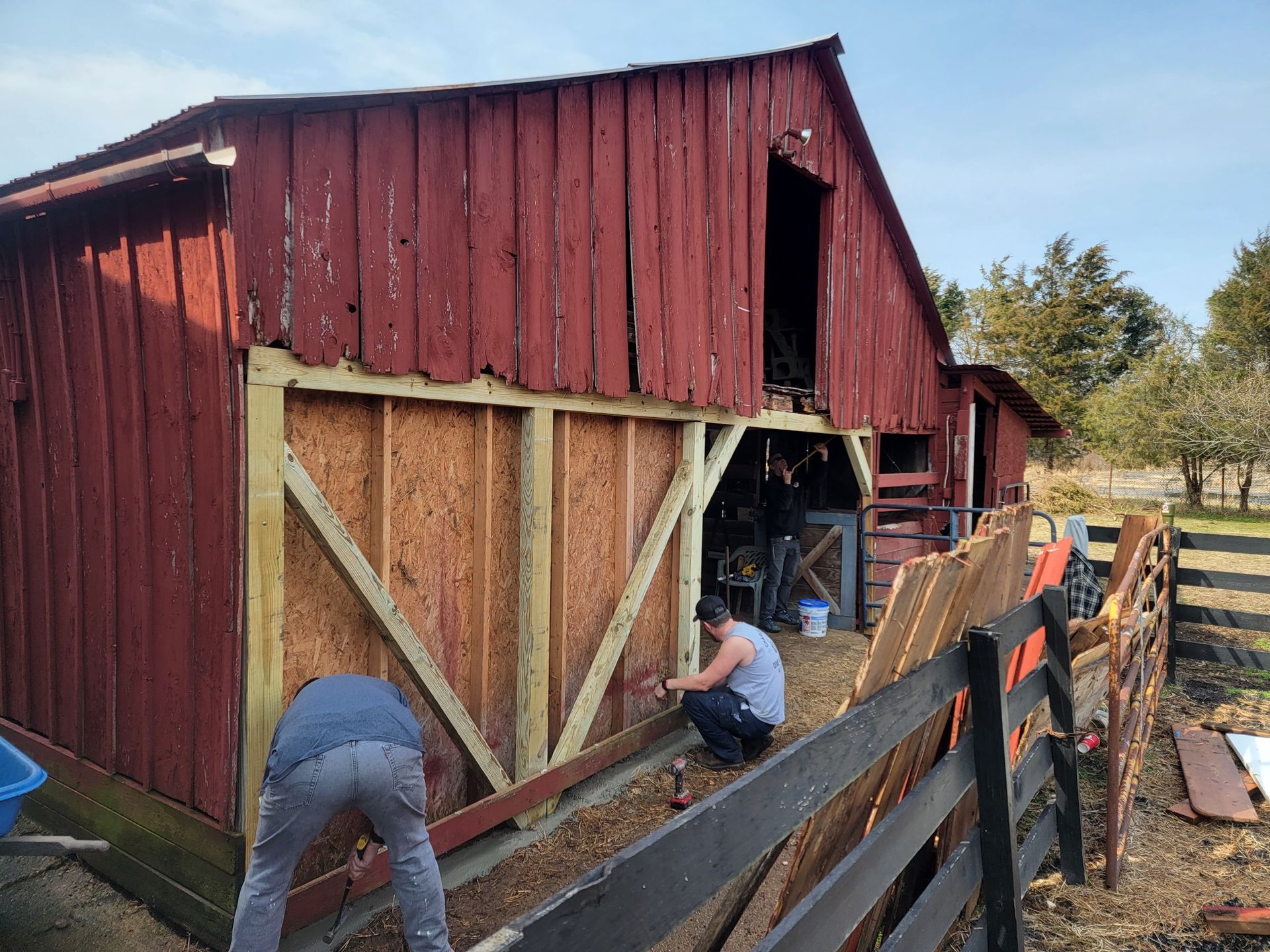 A group of people are working on a barn.