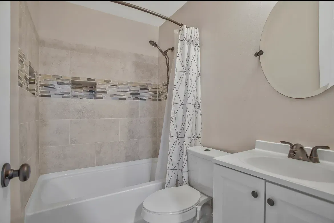 A bathroom with a toilet , sink and bathtub