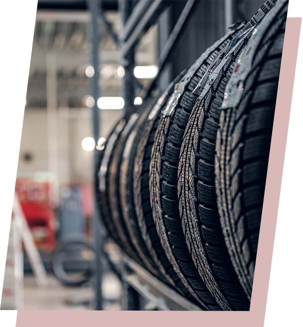 Tires lined up on a metal rack inside a warehouse or storage facility.