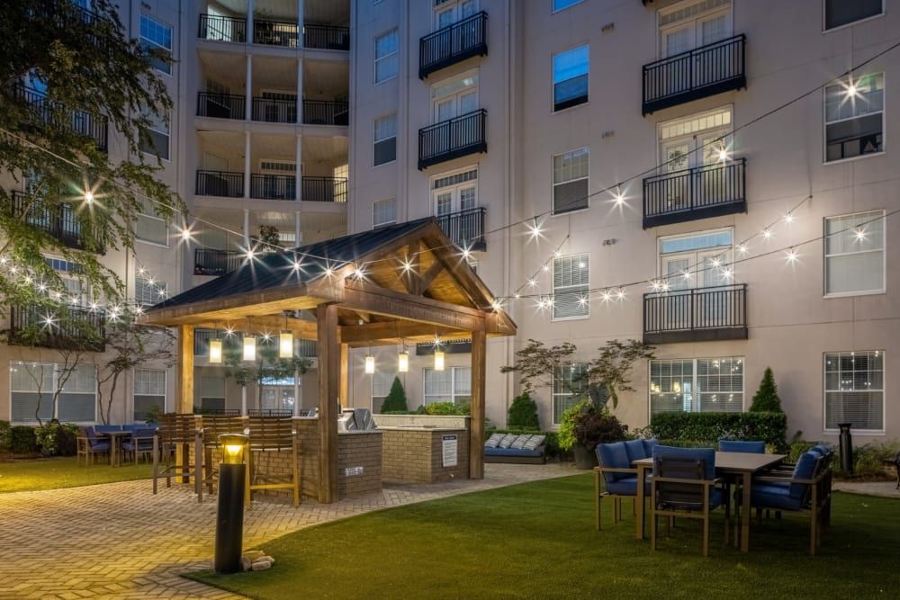 A building with a gazebo and tables and chairs in front of it at Marq on Ponce.