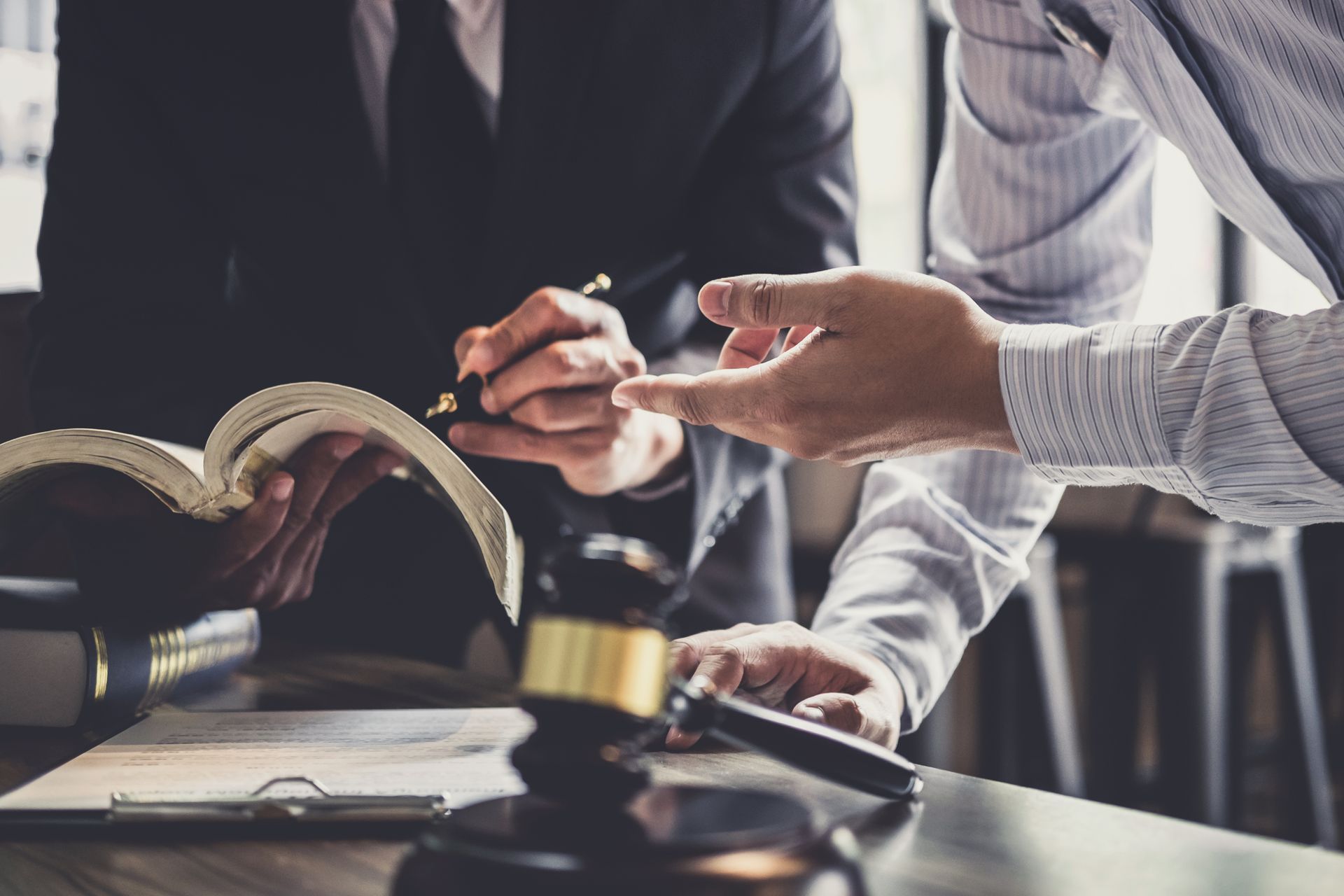 Lawyer reviewing documents with a client, scales of justice on the table.