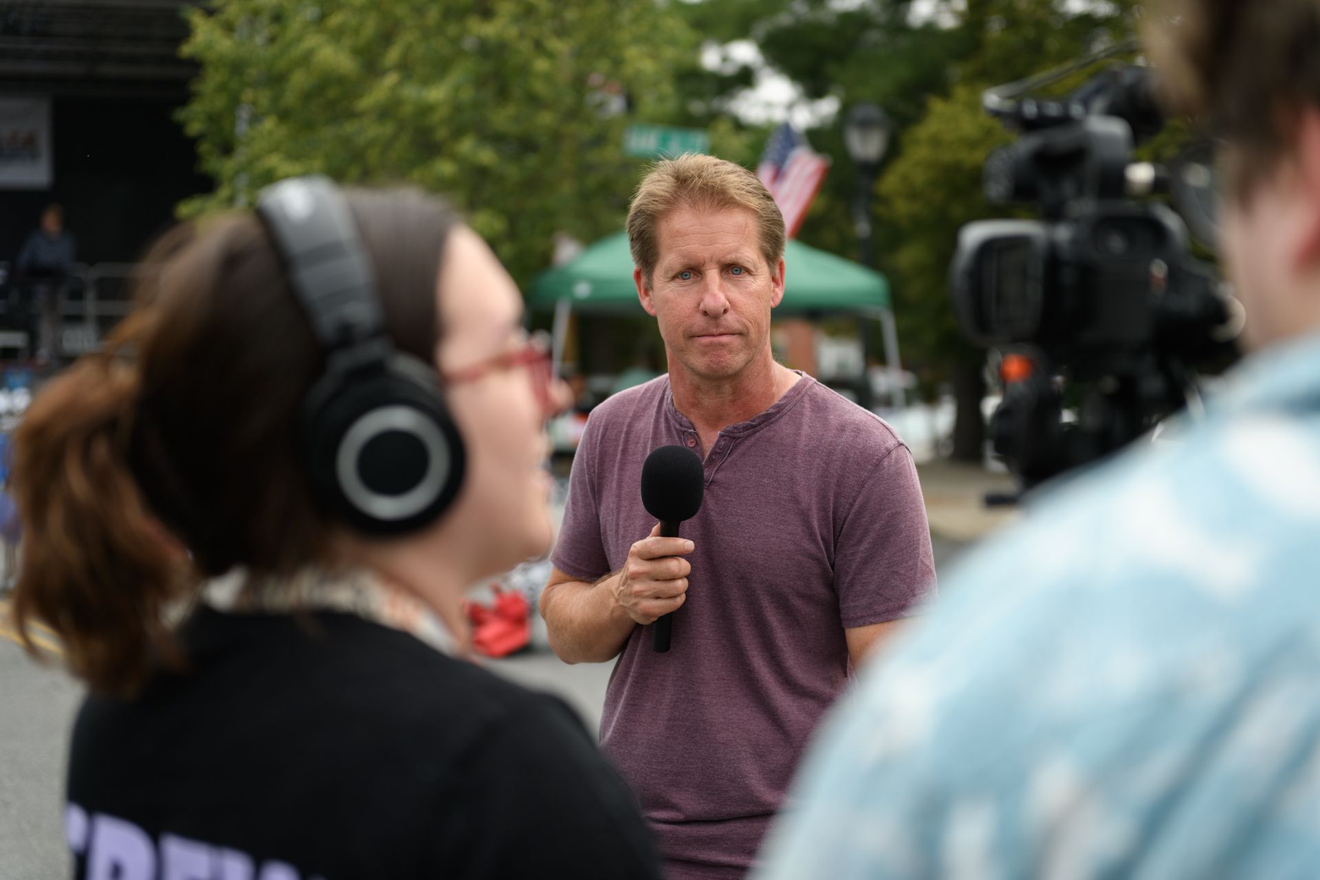A man is talking into a microphone while wearing headphones