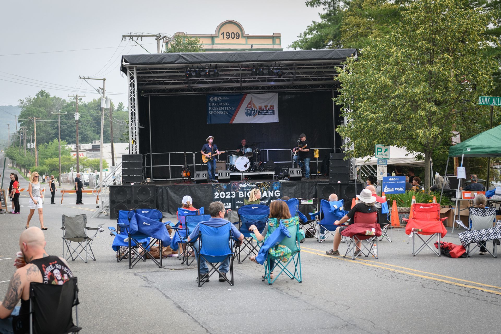 A group of people are sitting in chairs in front of a stage.