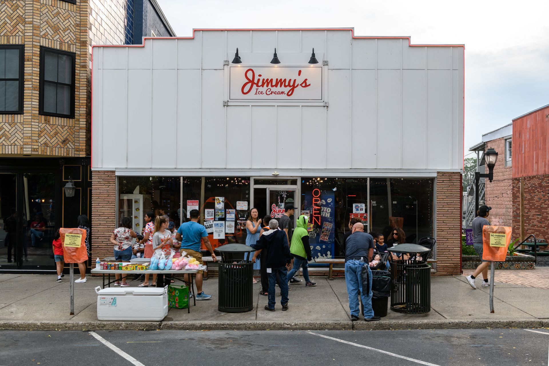 A group of people are standing outside of jimmy 's restaurant.