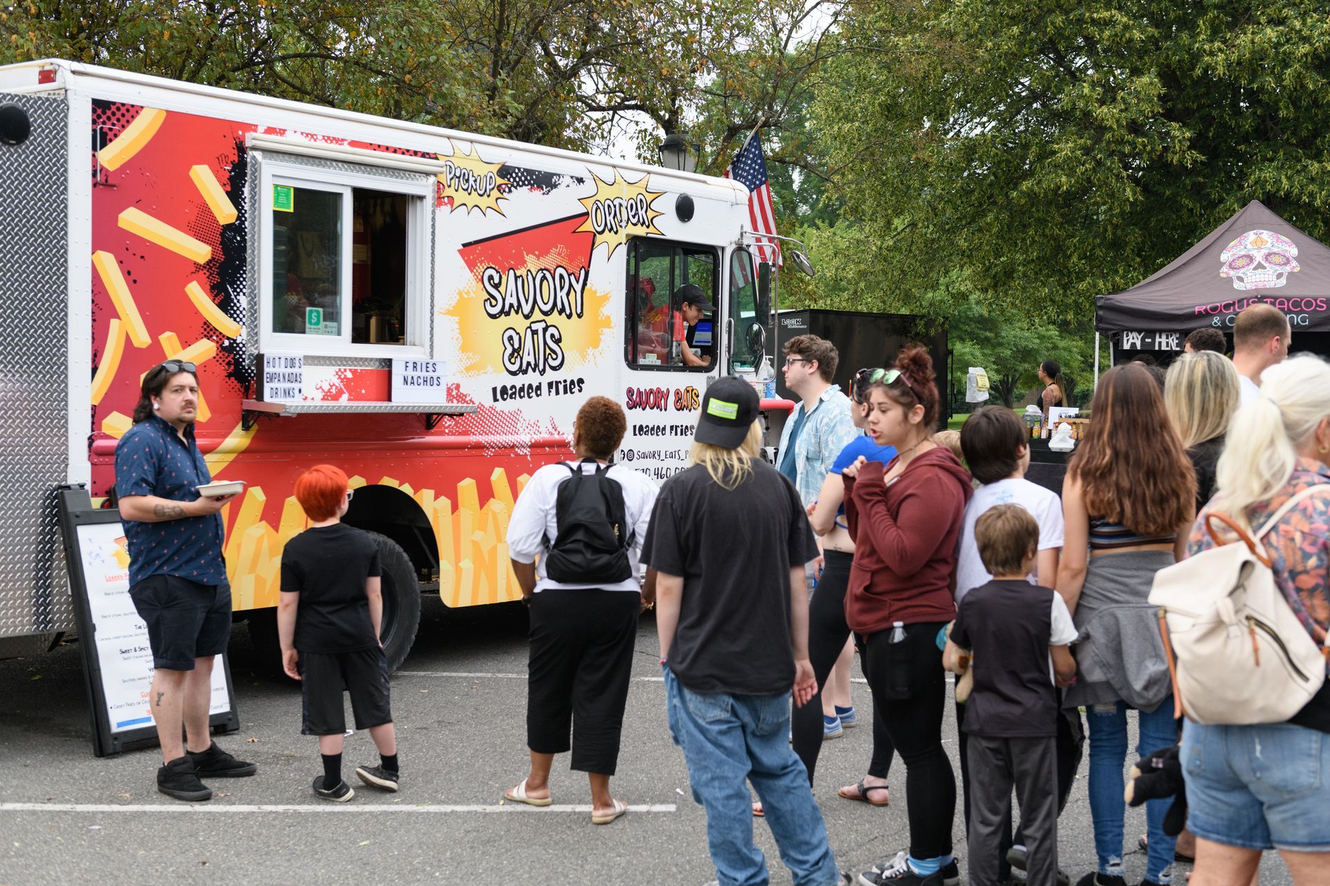 A group of people are standing in front of a food truck.